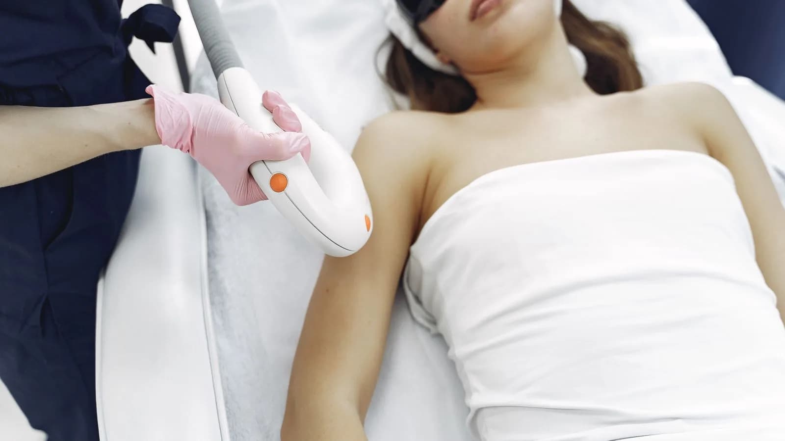Laser hair removal treatment in progress at a Cardiff beauty clinic, with a practitioner using a handheld laser device on a client wearing protective eyewear